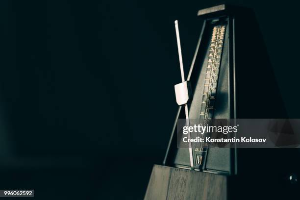 vintage metronome, on a dark background. - metronomo foto e immagini stock