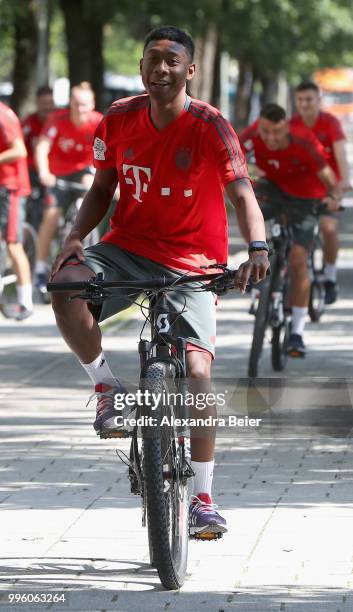 David Alaba of FC Bayern Muenchen rides a bicycle during a training session near the club's Saebener Strasse training ground on July 12, 2018 in...