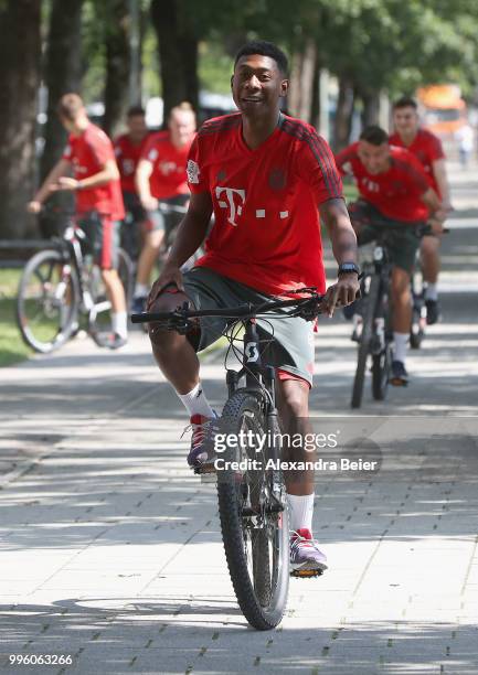 David Alaba of FC Bayern Muenchen rides a bicycle during a training session near the club's Saebener Strasse training ground on July 12, 2018 in...