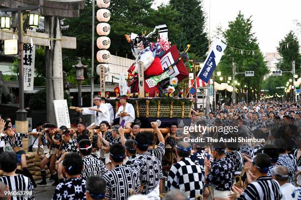 Members of 'Doinagare' team carry 'Kakiyama' float during the 'Asayama,' morning session as a part of the Hakata Gion Yamakasa festival on July 11,...