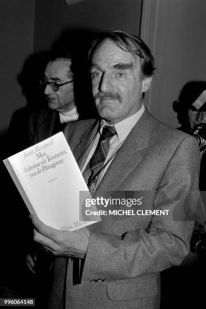 French writer Jean Raspail poses on November 5, 1981 with his book "Moi, Antoine de Tounens, roi de Patagonie", "I, Antoine de Tounens, King of...