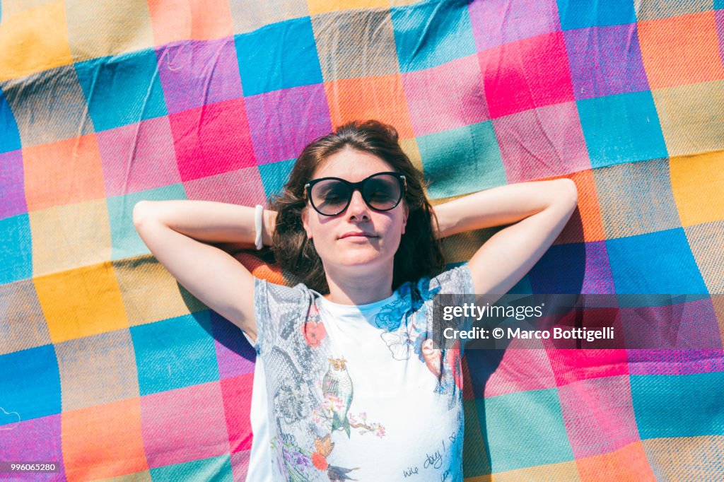Adult woman relaxing on a colorful mat