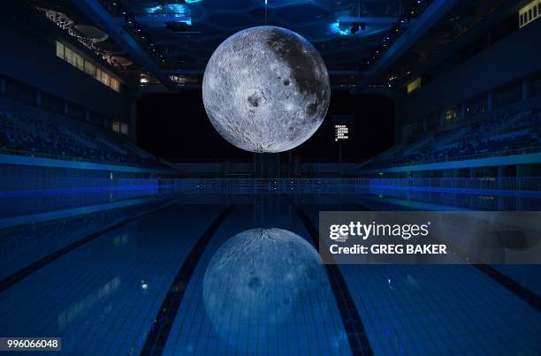 Model of the moon hangs above the Olympic swimming pool at the National Aquatics Center, known as the Water Cube, in Beijing on July 11, 2018. - The...