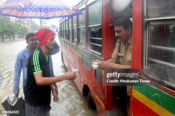 Residents of Hindamata serving tea & refreshments to stranded BEST Bus Conductor & passengers, at Parel, on July 10, 2018 in Mumbai, India. Heavy...