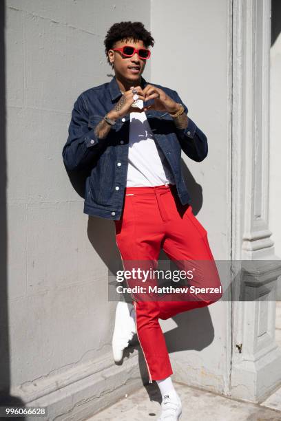 Kelly Oubre Jr. Is seen on the street attending Men's New York Fashion Week wearing denim jacket and red pants on July 10, 2018 in New York City.