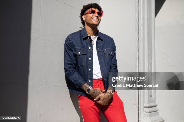 Kelly Oubre Jr. Is seen on the street attending Men's New York Fashion Week wearing denim jacket and red pants on July 10, 2018 in New York City.