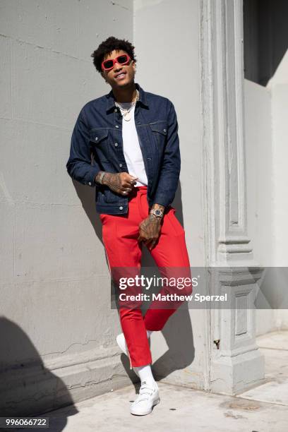 Kelly Oubre Jr. Is seen on the street attending Men's New York Fashion Week wearing denim jacket and red pants on July 10, 2018 in New York City.