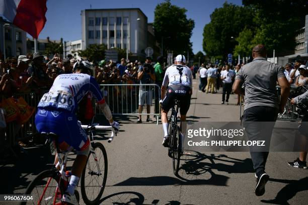 Great Britain's Christopher Froome is escorted by a bodyguard as he cycles in the departing area within the signing in ceremony, prior to the fifth...