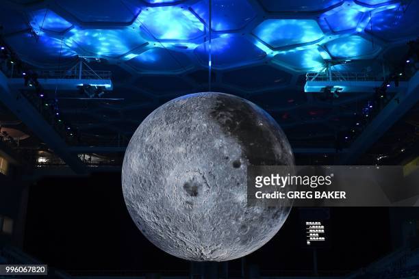 Model of the moon hangs above the Olympic swimming pool at the National Aquatics Center, known as the Water Cube, in Beijing on July 11, 2018. - The...