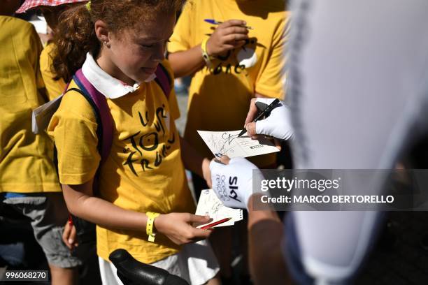 Great Britain's Christopher Froome signs an autograph to a young fan prior to the fifth stage of the 105th edition of the Tour de France cycling race...