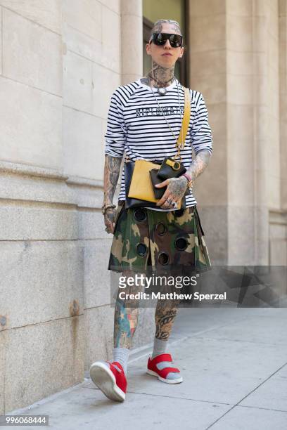 Chris Lavish is seen on the street attending Men's New York Fashion Week wearing Diplomacy shirt, Friedman kilt by Mickey, Moschino glasses, Versace...