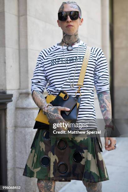 Chris Lavish is seen on the street attending Men's New York Fashion Week wearing Diplomacy shirt, Friedman kilt by Mickey, Moschino glasses, Versace...