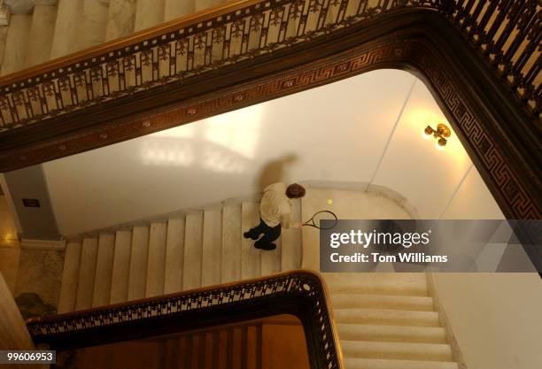 Russell Building staffer bounce a tennis ball on a staircase.