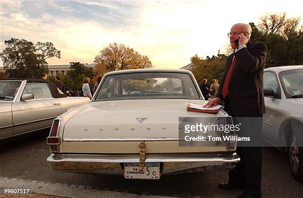 Rep. Vernon Elhers, R-Mich., does work on the back of a 1964 Plymouth Valiant owned by Rep. Gary Ackerman, D-N.Y. Ehlers is temporarily displaced...