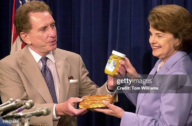 Sen. Arlen Specter, R-PA, presents pretzels and mustard from Philadelphia to Sen. Diane Feinstein, D-CA, as a result of a lost bet on the NBA Finals...