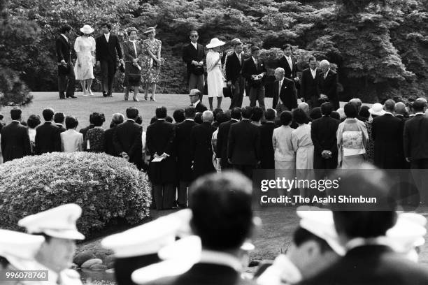 Emperor Hirohito and royal family members walk toward guests prior to the Spring Garden Party at the Akasaka Imperial Garden on May 16, 1986 in...