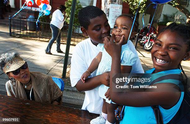 Herbert Little and his sister Trenise try to cheer up their cousin Mika Minor, 18 months while great-great grandmother Pearl Minor looks on at the...