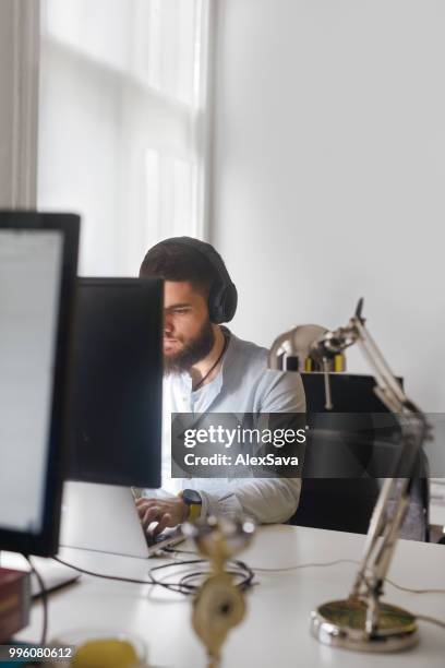 young man working at laptop in the office - rgb stock pictures, royalty-free photos & images