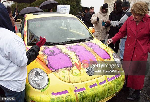 Rep. Louise Slaughter, Co-Chair, Congressional Arts Caucus, paints a VW New Beetle Congressional Arts Caucus before a press conference to launch...