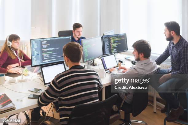 equipo de trabajo en la oficina de desarrollo de software - depuración de programas fotografías e imágenes de stock