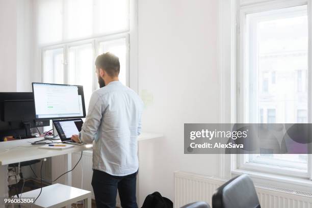 オフィスで彼のラップトップに取り組んでいる男性の開発者 - rgb ストックフォトと画像