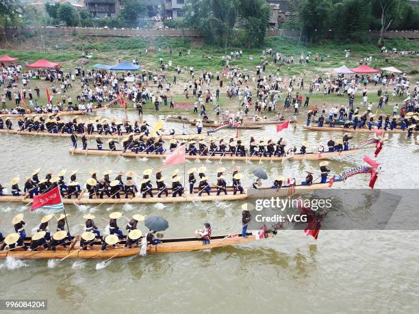 People of Miao Ethnic Group of Taijiang County compete in a dragon boat race on Qingshui River to celebrate the Dragon Canoe Festival at Shidong Town...