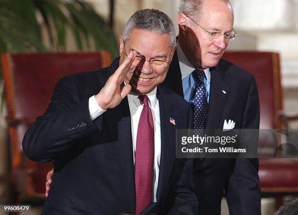 Secretary of State Colin Powell, saluting, and Supreme Court Justice Anthony Kennedy attend a ceremony in the Rotunda of the Capitol Building to...