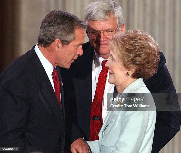 President George W. Bush, speaks to Nancy Reagan as Speaker Dennis Hastert, R-Ill., looks on at a ceremony in the Rotunda of the Capitol Building to...