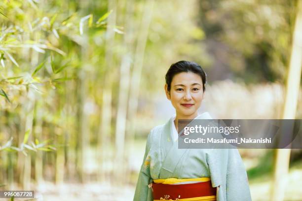 asia mujer vestida con un kimono, caminando en el bosque de bambús - masafumi nakanishi fotografías e imágenes de stock