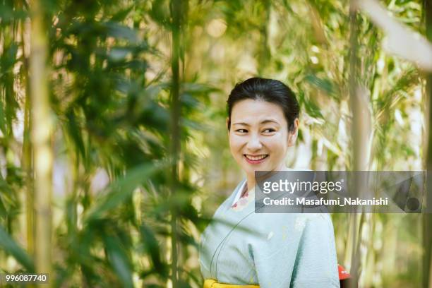 asia mujer vestida con un kimono, caminando en el bosque de bambús - masafumi nakanishi fotografías e imágenes de stock