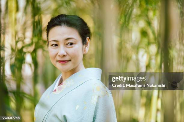 asia mujer vestida con un kimono, caminando en el bosque de bambús - masafumi nakanishi fotografías e imágenes de stock