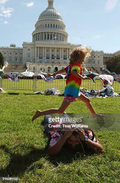 Ali Anderson of Ukiah Calif., jumps over her new friend Marty Dread of the Iao School Peace Team from Hawaii after his performance at "Symphony of...