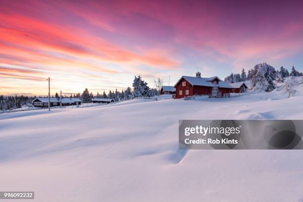 snowbound village after sunset - blokhut stockfoto's en -beelden