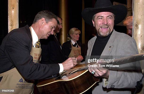 Ben Winter of the "Southern Nights Band" gets is guitar signed by Sen. John Breaux, D-LA, at the 19th Annual Gourmet Gala which had members of...