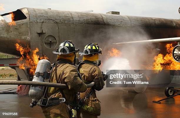 Firefighters from the D.C. Metropolitan Fire Department extinguish a 45-foot aircraft simulator on Garfield Circle, Capitol Hill. The 14th Annual...