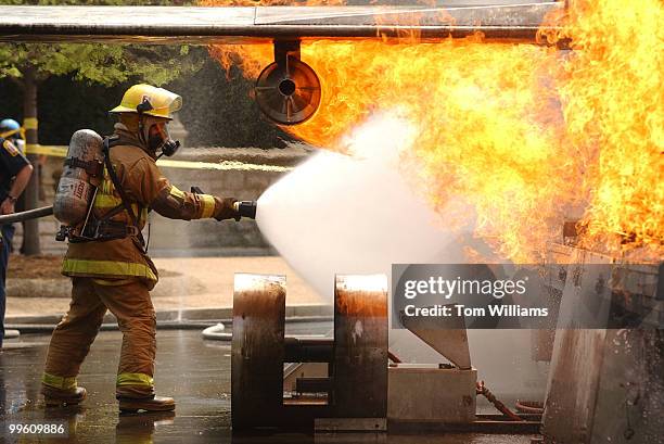 Firefighter from the D.C. Metropolitan Fire Department extinguishes a 45-foot aircraft simulator on Garfield Circle, Capitol Hill. The 14th Annual...