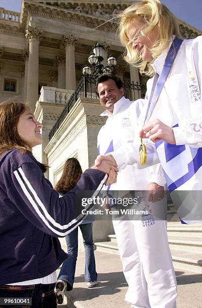Gold medalists Mike Eruzione of the 1980 Hockey Team and Nikki Stone from the 1998 Freestyle Ski Team, show off their medals to middle schoolers from...