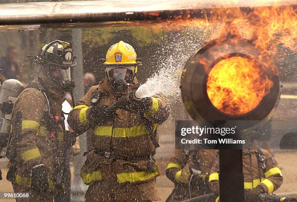 Firefighters from the D.C. Metropolitan Fire Department extinguish a 45-foot aircraft simulator on Garfield Circle, Capitol Hill. The 14th Annual...