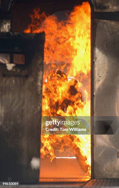 Firefighter from the D.C. Metropolitan Fire Department extinguishes a 45-foot aircraft simulator on Garfield Circle, Capitol Hill. The 14th Annual...