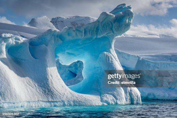 weather eroded iceberg in wilhemina bay antarctica - antarctica iceberg stock pictures, royalty-free photos & images