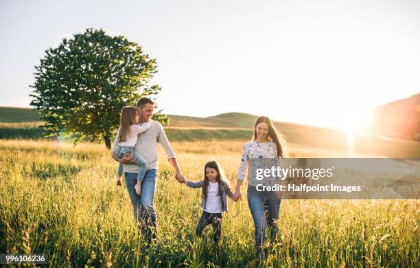 happy family with two small children walking outside in spring nature. - father sun stock pictures, royalty-free photos & images