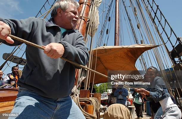 Wayne Thompson helps Tempress White and other high schoolers from Duke Ellington in Georgetown, lower a sail on the deck of La Amistad. A recreation...