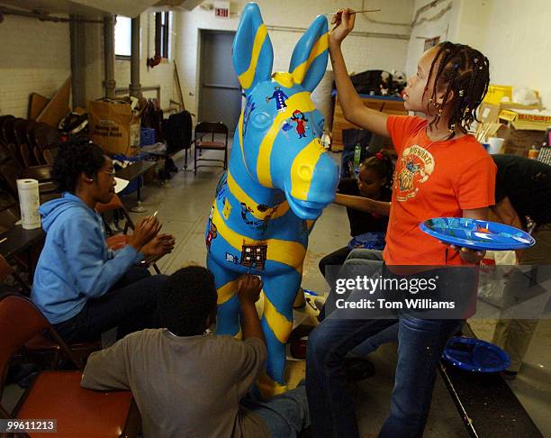Sixth grader Rickeya McClain paints a "Party Animal" donkey that will be one of 200 sculptures soon to adorn the streets of Washington DC, in a...