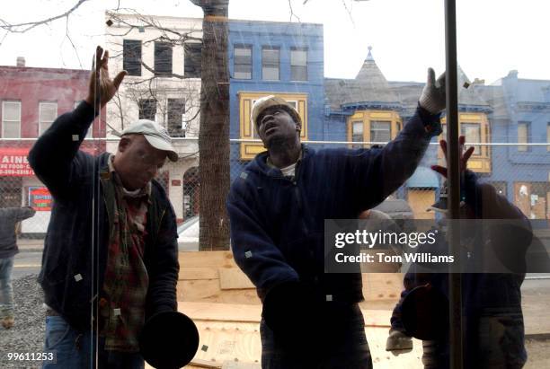 Workers install a front window on the the Atlas Performing Arts Center on H street, NE.