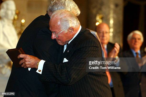 Former Rep. Bob Michel, R-Ill., embraces Speaker Dennis Hastert, R-Ill., during a ceremony in which Michel and three other former members received...