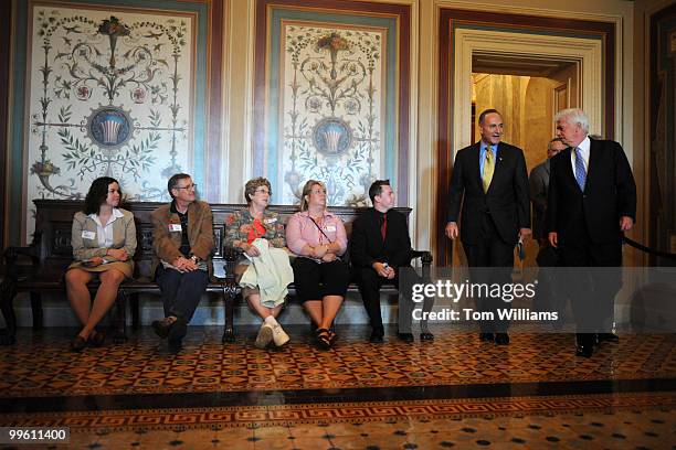 Tour group watches Sen. Charles Schumer, D-N.Y., left, and Senate Banking Committee Chairman Chris Dodd, D-Conn., walk to a meeting on the potential...