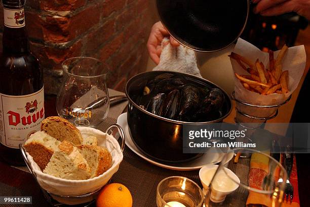 Chef Bart Vandaele takes the lid off a mussel dish at Belga Cafe on 8th St., SE.