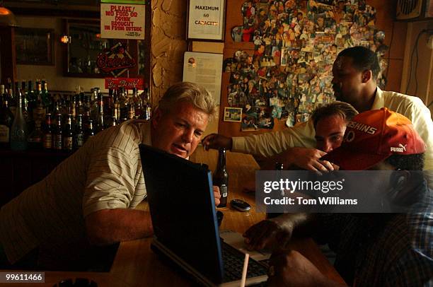 From left, bartender Pete Handley, Marcus Murchison, standing, Michael Johnston and Norris Kingsbur, look a real estate on Kingsbur's computer at Lil...