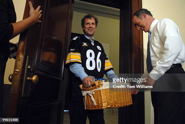 Sen. Sherrod Brown, D-Ohio, left, delivers goods from Ohio while wearing Steelers jersey to Sen. Bob Casey, D-Pa., as part of a bet pay off made on...