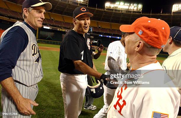 Rep. Jay Inslee, D-Wash., center, congratulates Rep. Kevin Brady, R-Texas, after the 44th Annual Roll Call Congressional Baseball Game at RFK Stadium...